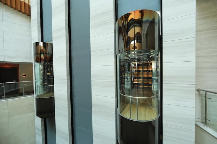 Glass capsule passenger elevators in a modern building lobby